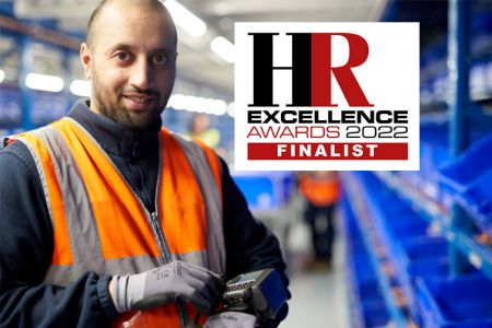 Male colleague looking into camera with wrist device and HR Excellence 2022 Finalist Logo_753x502.jpg