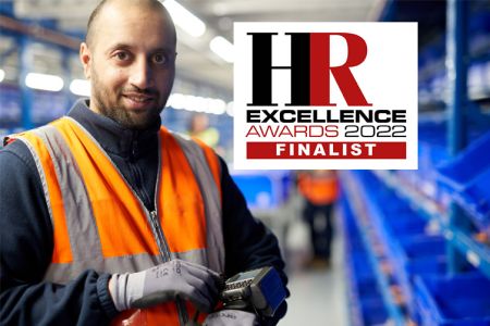 Male colleague looking into camera with wrist device and HR Excellence 2022 Finalist Logo_753x502.jpg